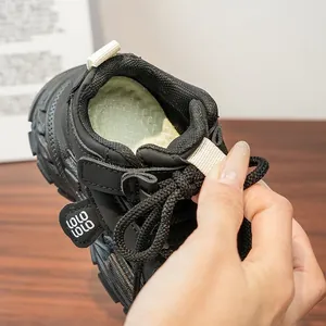 Détail de l'intérieur rembourré doux et des lacets noirs de la chaussure de sport enfant.