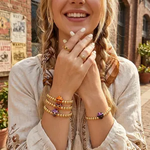 Detailed view of Halloween gold bead bracelets featuring pumpkin and skull charms