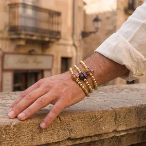 Detail view of Halloween themed gold beaded bracelets with festive pumpkin and skull charms.