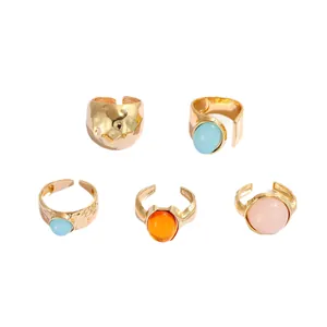 Set of five gold-colored alloy rings with colorful acrylic stones and irregular textures.