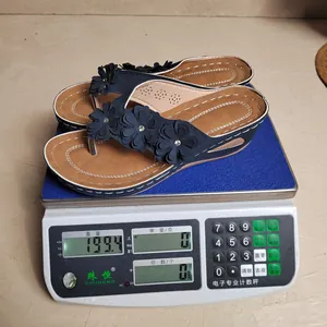 Gedetailleerd overzicht van het gewicht van 199,4 g van de blauwe bloemen teenslippers op schaal