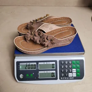 Detail van het gewicht van 200 g van stijlvolle dames slippers met bloemmotief op schaal