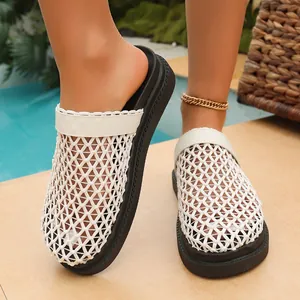 Λεπτομερής όψη γυναικείων λευκών πλεκτών clogs με δίχτυ και χοντρή μαύρη σόλα πλατφόρμα