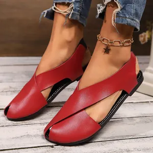 Detailansicht der stilvollen roten flachen Sandalen aus weichem Leder mit Kreuzgurt