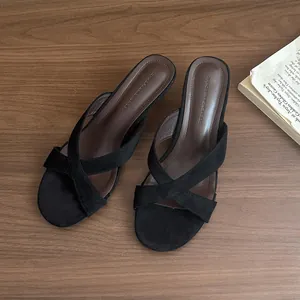 Eleganti ciabatte nere minimaliste con tacco alto e cinturini incrociati per l'estate