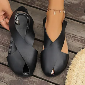 Nahaufnahme von schwarzen Sandalen aus weichem Leder mit Kreuzriemen und Peep-Toe-Design