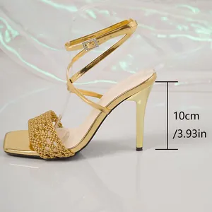 Detaillierte Seitenansicht goldene Stiletto-Sandalette mit 10 cm hohem Absatz und Riemen