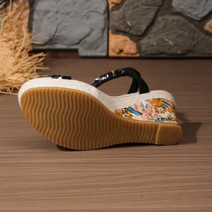 Detailansicht der Keilsandalette mit gewellter Gummisohle und floralem Absatzmuster