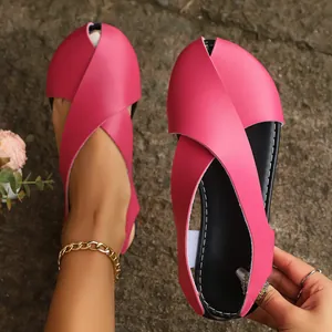 Detailansicht der flachen rosa Sandalen mit Kreuzgurten und Fischmaul-Design.