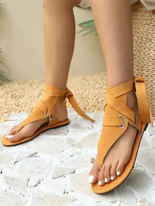 Detailansicht der gelben Gladiatoren-Sandalen mit Kreuzriemen und Schnallen-Detail.