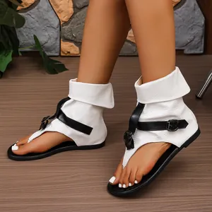 Detailansicht weißer römischer Sandalen mit Krokodilmuster und schwarzen Riemen.