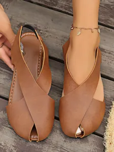 Nahaufnahme von braunen Peep-Toe-Sandalen aus weichem Leder mit Kreuzriemen