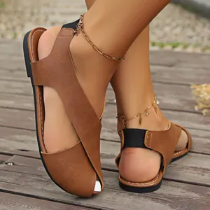 Detailansicht der braunen flachen Sandalen mit gekreuzten Riemen und elastischem Band
