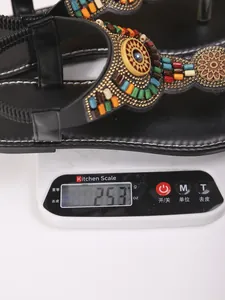 Detailopname van het lichte gewicht van bohemian teensandalen gewogen op een keukenweegschaal