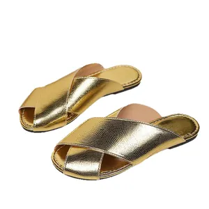 Elegant gold metallic snake-textured flat mule slippers for women with cross straps.