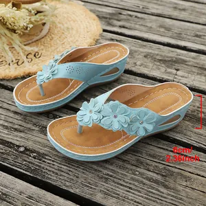 Zijaanzicht van lichtblauwe sleehak slippers met bloemen en 6 cm hakhoogte detail