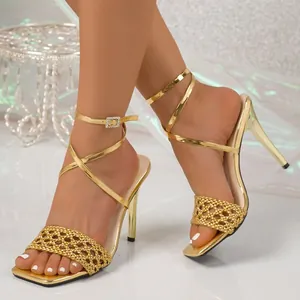 Elegante goldene Stiletto-Sandalen mit Karree-Zehenpartie, Webriemen und Schnürdesign.