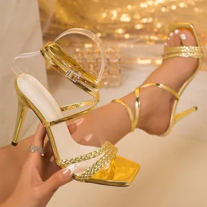 Detailansicht goldener Sandalen mit quadratischer Zehenpartie und geflochtenen Bändern
