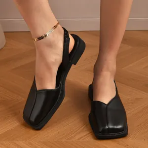 Primo piano di eleganti ballerine nere a punta quadrata con cinturino posteriore