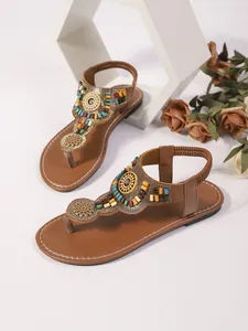 Gedetailleerd macrozicht op Boheemse platte sandalen met kleurrijke kralenversiering