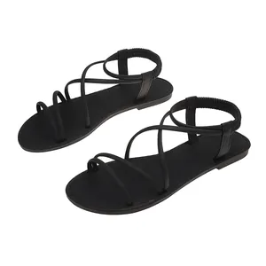 Detailed view of black flat Roman gladiator sandals with cross straps and elastic back