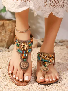 Detailopname van bohemian teenslippers met kleurrijke kralen en etnisch borduurwerk.