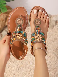 Boheemse platte teenslippers met kleurrijke kralen en mandala-patroon op zandgrond