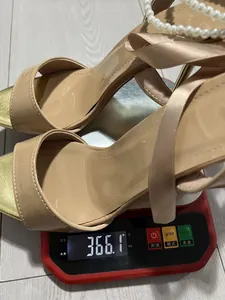 Weight display of sexy beige high heel sandals with ribbon straps and pearls.