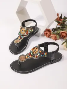 Detail van Boheemse teensandalen met kleurrijke etnische kralendecoratie.