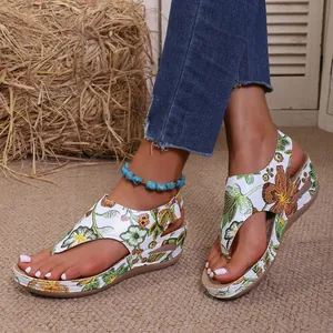 Primo piano di sandali con zeppa a fiori da donna con suole spesse per l'estate.