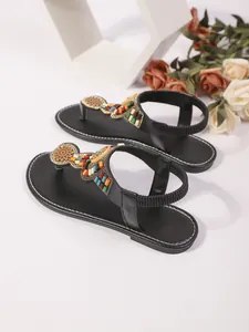 Gedetailleerd overzicht van boheemse platte sandalen met kleurrijke kralen en riem