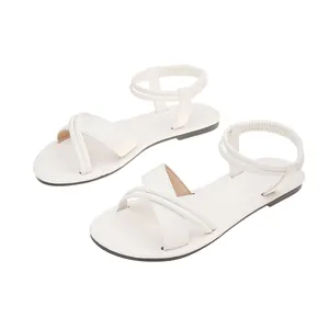 Close-up of white women's flat Roman sandals with cross straps and elastic heel