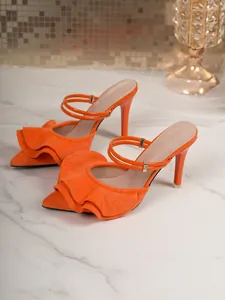 Detail of elegant orange suede pointed toe high heels with chic ruffle decoration.