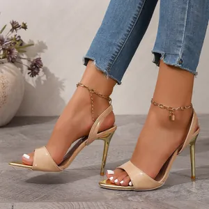 Elegant nude patent leather high heels with gold stiletto and padlock chain detail.