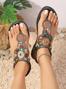 Bohemian T-strap platte sandalen met kleurrijke kralen op een zandstrand achtergrond