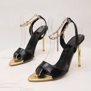 Detailed macro view of sexy black patent leather sandals with gold stiletto heels