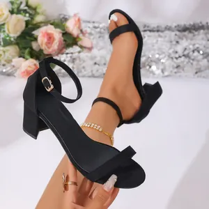 Detailed view of elegant black suede block heel sandals with an adjustable ankle strap