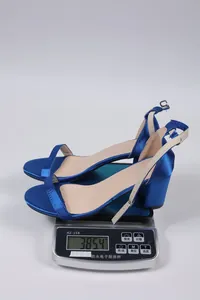 Detail view showing blue satin chunky heel sandals on a digital scale weighing 385.4g