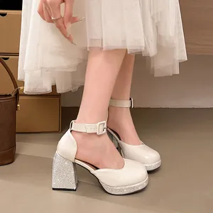 Detailed view of cream patent leather Mary Jane shoes with rhinestone block heels