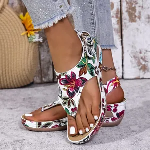 Vista dettagliata dei sandali con zeppa floreali da donna con base bianca e design infradito