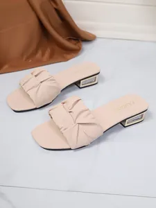 Detailweergave van dames slippers met plooien, glitter blokhak en vierkante neus
