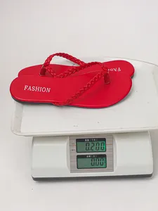 Vista dettagliata di un sandalo infradito rosso intrecciato da 0,200 kg su bilancia