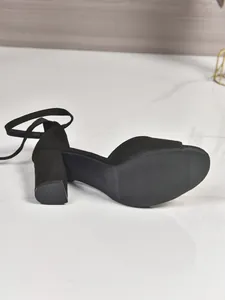 Detailed view showcasing the sole and sturdy chunky heel of these black sandals.