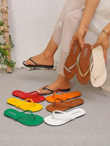 Infradito piatte da donna taglie forti in colori vivaci con cinturini intrecciati.