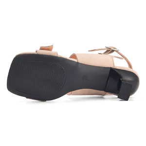 Close-up view of the anti-slip sole and sculptural heel on a beige suede sandal