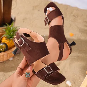 Detailed macro view of dark brown suede mule sandals with sculptural kitten heels.