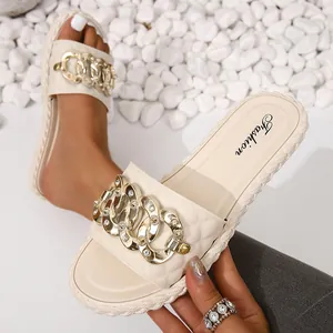 Gros plan de claquettes pour femmes avec chaîne en métal strass et semelle