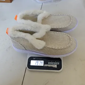 Pantofole da donna foderate in peluche su una bilancia che indica un peso di 197,4g