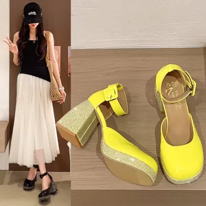 Detailed view of yellow patent leather Mary Jane shoes with rhinestone block heels.