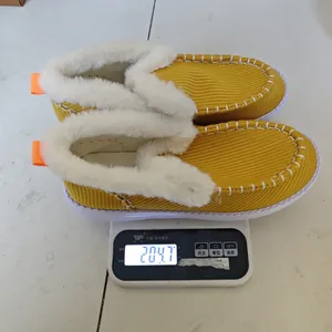 Pantofole invernali in velluto giallo con fodera in peluche su una bilancia digitale
